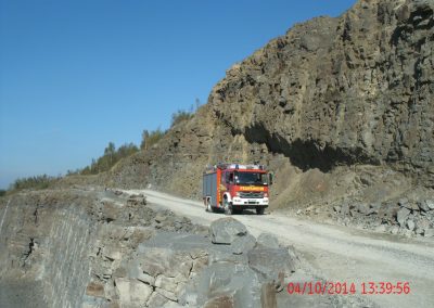 Einsatz Fahrzeuge der Feuerwehr fahren den Steinbruch entlang, rechts von Ihnen hohe Stein Wände und Links geht es tief runter in den Steinbruch