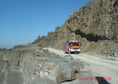 Einsatz Fahrzeuge der Feuerwehr fahren den Steinbruch entlang, rchts von Ihnen hohe Stein Wände und Links geht es tief runter in den Steinbruch