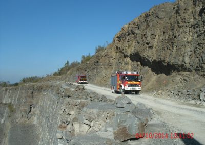Einsatz Fahrzeuge der Feuerwehr fahren den Steinbruch entlang, rechts von Ihnen hohe Stein Wände und Links geht es tief runter in den Steinbruch