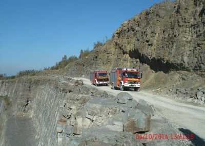 Einsatz Fahrzeuge der Feuerwehr fahren den Steinbruch entlang, rechts von Ihnen hohe Stein Wände und Links geht es tief runter in den Steinbruch